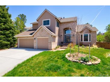 Charming two-story home featuring a manicured lawn, brick accents, and a spacious three-car garage at 9688 Chesapeake St, Highlands Ranch, CO 80126