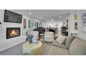 Open-concept living room featuring a fireplace, piano, and comfortable seating for relaxing or entertaining guests at 3470 S Race St, Englewood, CO 80113