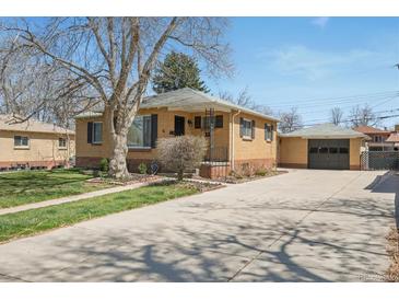 Charming brick home with a large front yard and a detached garage accessible via a long driveway at 2562 S Xavier St, Denver, CO 80219