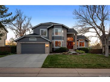 Beautiful two-story home with a well-manicured lawn, brick accents, and an attached two-car garage at 2042 Chesapeake Pl, Highlands Ranch, CO 80126