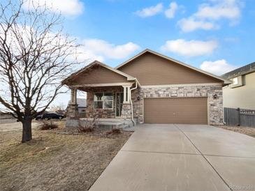 Ranch style home with stone accents, two-car garage, and landscaping at 5242 Longs Peak St, Brighton, CO 80601