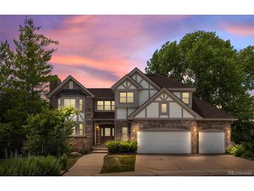 Gorgeous two-story home featuring a brick facade, well-maintained landscaping, and a three-car garage at 9117 Buck Hill Dr, Highlands Ranch, CO 80126
