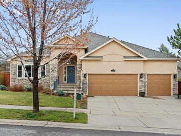 Charming single-Gathering home featuring a three-car garage, stone accents, and a manicured front yard at 5497 W Prentice Ct, Littleton, CO 80123