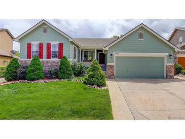 Charming home featuring a well-manicured lawn, red shutters, and beautiful landscaping at 2840 Canyon Crest Ln, Highlands Ranch, CO 80126