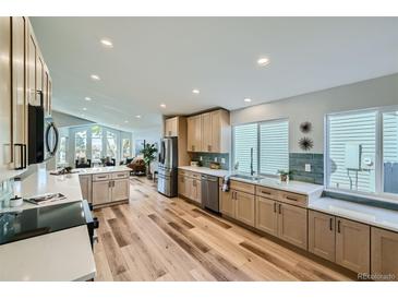 Modern kitchen with stainless steel appliances and light wood cabinets at 11854 Vallejo St, Denver, CO 80234