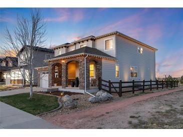 Charming two-story home with stone accents and a cozy covered porch, fenced yard, and professional landscape lighting at 11582 Jimenez St, Parker, CO 80134