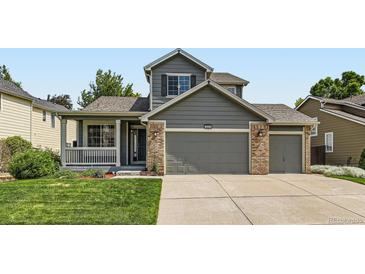 Charming home featuring a well-manicured lawn, covered porch, and two-car garage at 13472 Columbine Cir, Thornton, CO 80241
