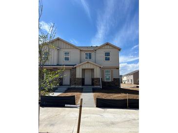 New construction two-story home featuring stone accents, a modern design, and a well-maintained yard at 5743 N Lisbon St, Aurora, CO 80019