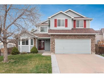 Charming two-story home featuring stone accents, gray siding, red shutters, and a well-maintained front yard at 23955 Glenmoor Way, Parker, CO 80138