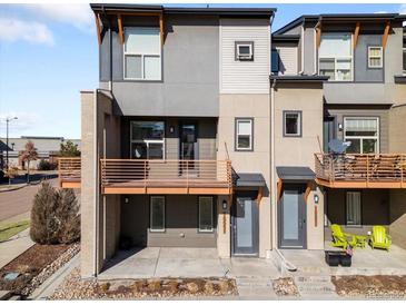Modern townhome exterior featuring dual balconies, neutral color scheme, and well-maintained landscaping at 10051 Belvedere Cir, Lone Tree, CO 80124