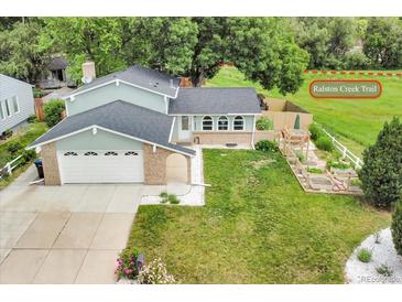 Charming home with a two-car garage, beautiful lawn, and an adjacent path, inviting outdoor adventures at 10869 W 65Th Way, Arvada, CO 80004