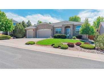 Charming single-story home with manicured lawn, brick exterior, and a two-car garage at 7211 Dolomite Ln, Castle Rock, CO 80108