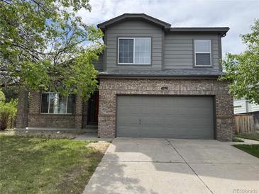 Charming two-story home featuring a gray exterior, brick accents, and a two-car garage at 4338 N Ceylon Ct, Denver, CO 80249