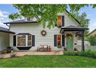 Charming two-story home with a quaint front porch and well-maintained landscaping at 6830 Lamar St, Arvada, CO 80003