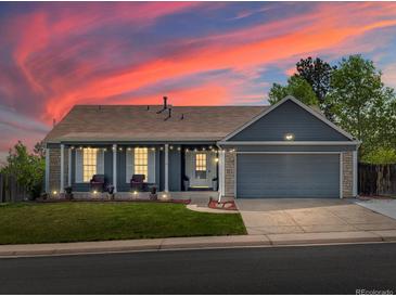 Charming single-Gathering home featuring a well-maintained lawn, covered porch, and two-car garage at 5342 S Halifax Cir, Centennial, CO 80015