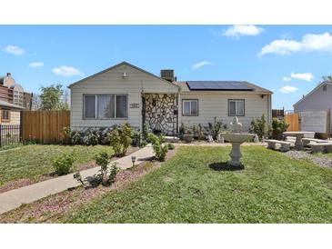 Charming single-story home with a stone accent wall, solar panels, and a well-manicured front yard at 1242 S Seneca Way, Denver, CO 80223