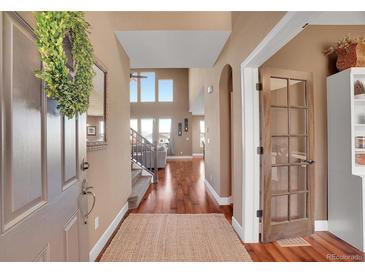 Inviting foyer with hardwood floors, wreath decor, and a view into the living space at 8726 Gardenia Cir, Arvada, CO 80005