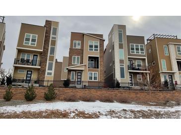 Modern townhomes boast contemporary designs, accented by stone and varying color schemes at 2617 Channel Dr, Highlands Ranch, CO 80129