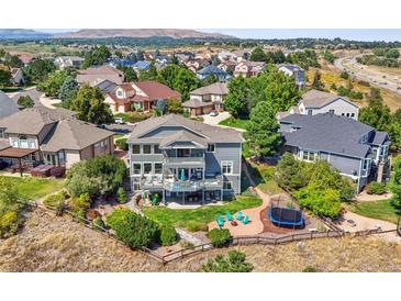 Luxury home with a spacious backyard, deck, and trampoline, offering stunning views at 10520 W Vassar Dr, Denver, CO 80227