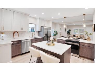 Modern kitchen featuring a center island, stainless steel appliances, and two-tone cabinets at 7204 W 26Th Ave, Lakewood, CO 80214