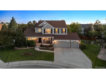 Two-story home with a large front yard, a well-manicured lawn, and a three-car garage at 3566 E Meadow Creek Pl, Highlands Ranch, CO 80126