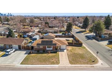 Charming single-story home with solar panels, a well-maintained lawn, and a driveway leading to an attached garage at 96 S Depew Dr, Lakewood, CO 80226