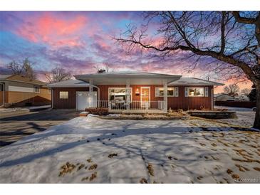 Brick ranch house with snow-covered lawn and attached garage at 2994 S Winona Ct, Denver, CO 80236