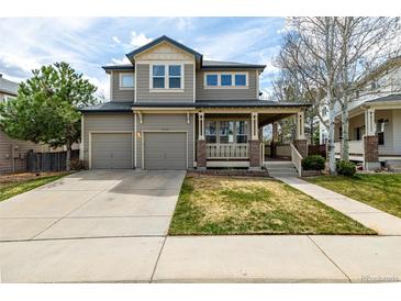 Charming two-story home featuring a covered front porch and a well-manicured lawn at 16434 Homestead Ct, Parker, CO 80134