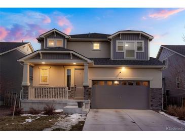 Charming two-story home featuring stone accents, covered front porch, and attached two-car garage at 26322 E 2Nd Ave, Aurora, CO 80018