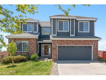 Charming two-story home featuring a brick facade, gray siding, and attached two-car garage, plus a well-manicured lawn at 2509 S Bahama Way, Aurora, CO 80013
