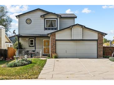 Two-story house with attached garage and landscaped front yard at 6195 Xavier Ct, Arvada, CO 80003