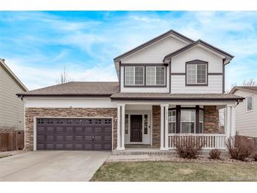 Charming two-story home featuring stone accents, a covered front porch, and a well-manicured lawn at 18948 E Baker Pl, Aurora, CO 80013