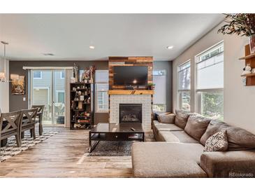 Bright living room boasts a fireplace, wood floors, and a cozy seating area, perfect for relaxation and entertaining guests at 3075 Distant Rock Ave, Castle Rock, CO 80109