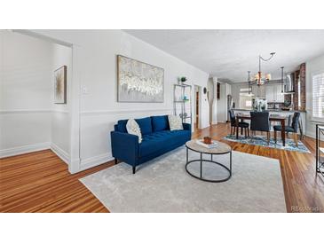 Bright and airy living room featuring hardwood floors, stylish furnishings, and a seamless flow to the dining area at 2772 Julian St, Denver, CO 80211