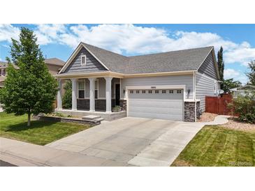 Charming single-Gathering home boasts a well-maintained lawn, attached two-car garage, and inviting front porch at 3885 Sandoval St, Brighton, CO 80601