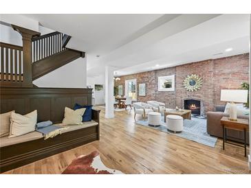 Bright, open living space featuring a brick fireplace, hardwood floors, and a cozy seating area at 734 N Downing St, Denver, CO 80218