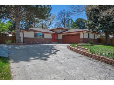 Charming single-story home featuring a red front door and lush landscaping at 12378 E Cedar Cir, Aurora, CO 80012
