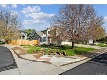 Charming two-story home with a well-maintained front yard, mature trees, and beautiful landscaping at 12705 Home Farm Dr, Westminster, CO 80234