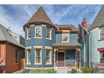 Charming two-story blue home with a turret and a cozy front porch perfect for relaxing at 209 S Lincoln St, Denver, CO 80209