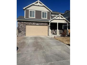 Charming two-story home with stone accents, large garage, and well-maintained front yard at 13563 E 106Th Pl, Commerce City, CO 80022