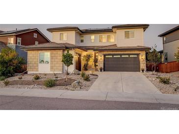 Beautiful two-story home featuring a two-car garage and manicured front yard at 14077 Yellow Tip Drive, Parker, CO 80134