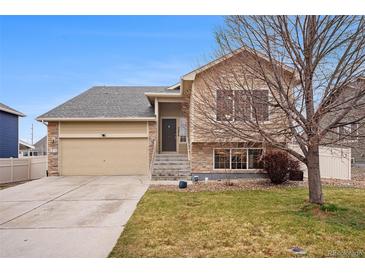 Charming two-story home with a well-manicured lawn, two car garage, and a stone and siding exterior at 5210 Roadrunner Ave, Firestone, CO 80504