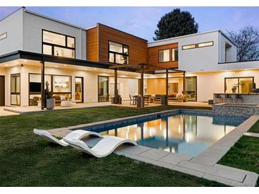 Stunning backyard oasis featuring a modern pool, lounge chairs, and expansive outdoor living spaces at 1 S Forest St, Denver, CO 80246