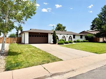 Charming ranch-style home with a well-manicured lawn, a long driveway, and a two car garage in a suburban setting at 4192 S Vrain St, Denver, CO 80236