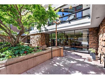 Stone and concrete building entrance with large glass windows and landscaping at 1020 15Th St # 210, Denver, CO 80202
