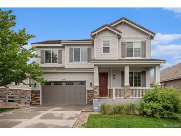 Charming two-story home with gray siding, stone accents, a covered porch, and a two-car garage at 3266 Yale Dr, Broomfield, CO 80023