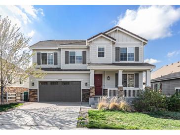 Charming two-story home with covered porch, gray siding, and a meticulously maintained front yard at 3266 Yale Dr, Broomfield, CO 80023