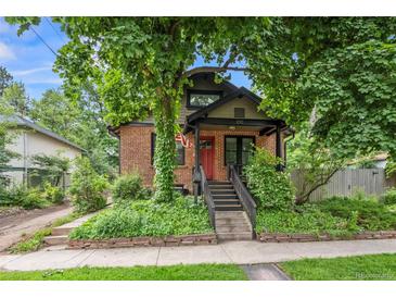 Charming brick home with mature trees, inviting porch, and landscaped front yard offers curb appeal at 1010 Euclid Ave, Boulder, CO 80302