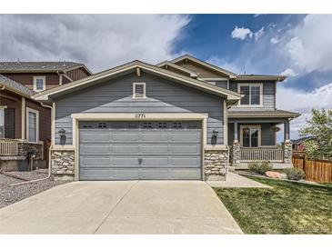 Charming two-story home with a gray siding, stone accents, and a large two car garage at 11771 W Quarles Ave, Littleton, CO 80127