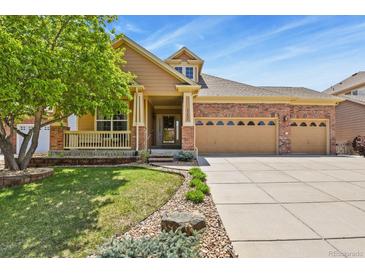 Charming two-story home with manicured lawn, brick accents, and spacious three car garage at 23426 Briar Leaf Ave, Parker, CO 80138